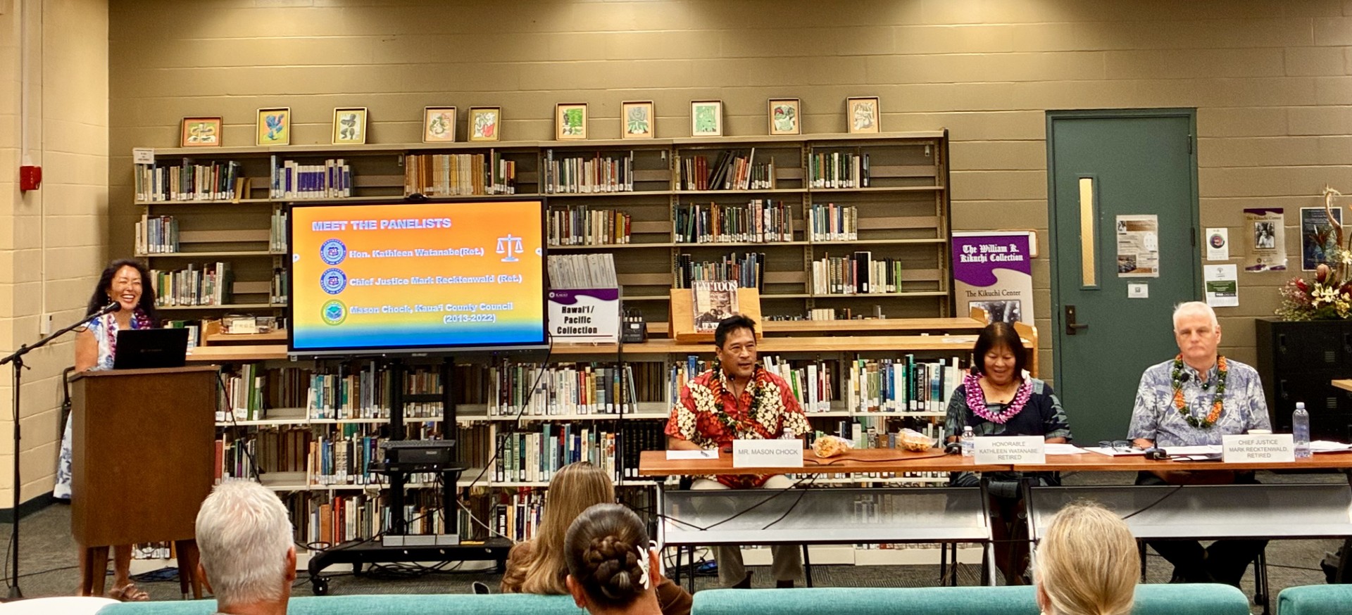 Moderator Jenny Silbiger at the podium while panelists listen at the table